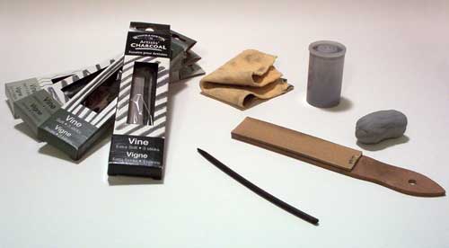 Vine Charcoal Drawing Supplies - clockwise from left: vine charcoal in various densities, chamois, film canister for storing charcoal dust, sharpening block, vine charcoal stick